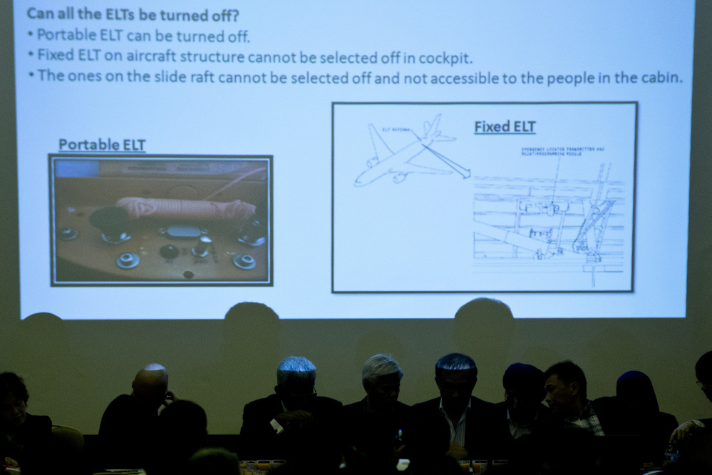Malaysian officials attend a presentation in Beijing on Monday for the relatives of Chinese passengers onboard Malaysia Airlines Flight 370. Pictures of emergency locater transmitters are being shown during the presentation.