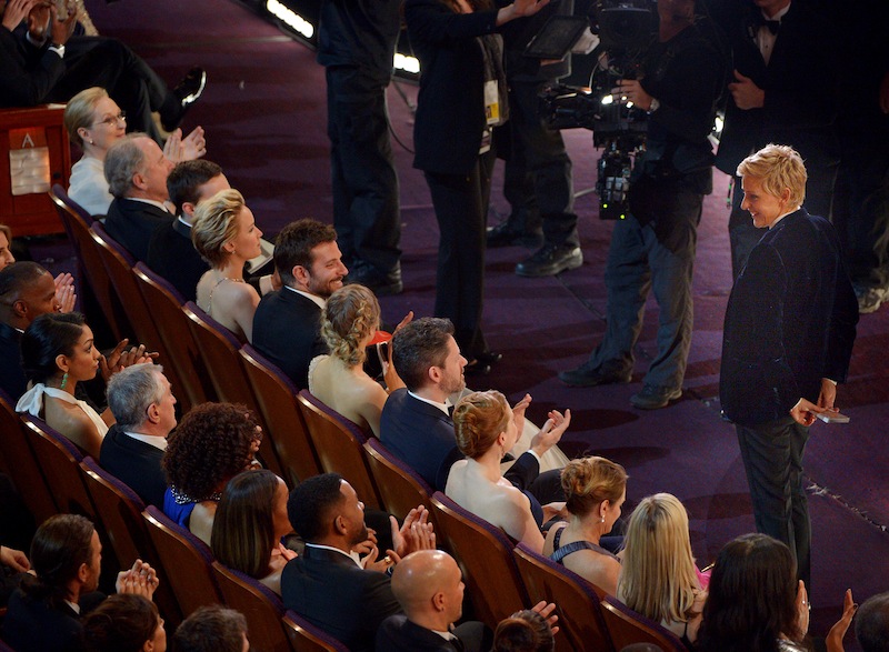 Ellen DeGeneres, right, stands in the audience during the Oscars at the Dolby Theatre on Sunday, March 2, 2014, in Los Angeles.
