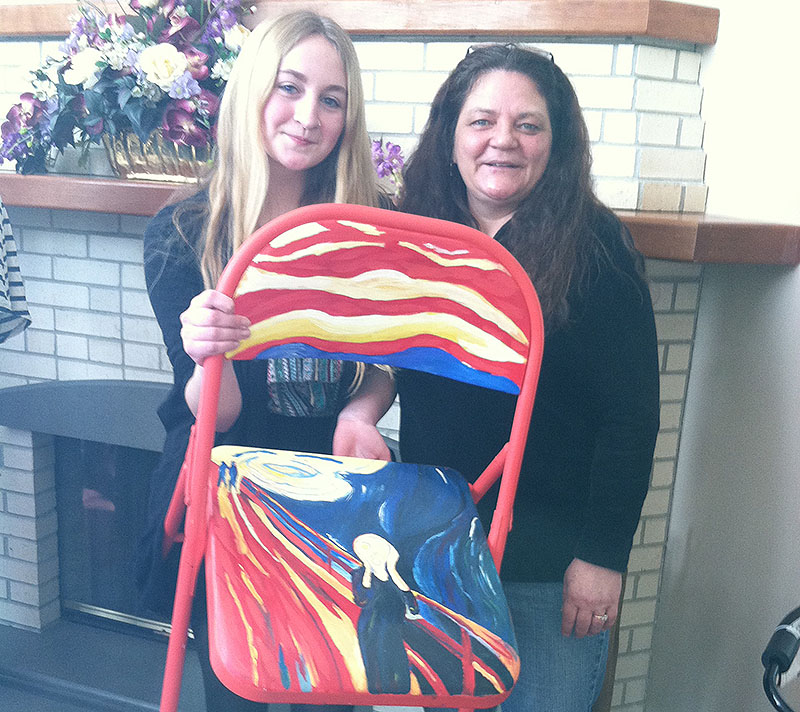 Caitlyn Duffy holds up her chair artwork. Mom Sharlene Duffy, right, said she was “blown away” by the thought process behind Caitlyn’s decision to paint “The Scream.”