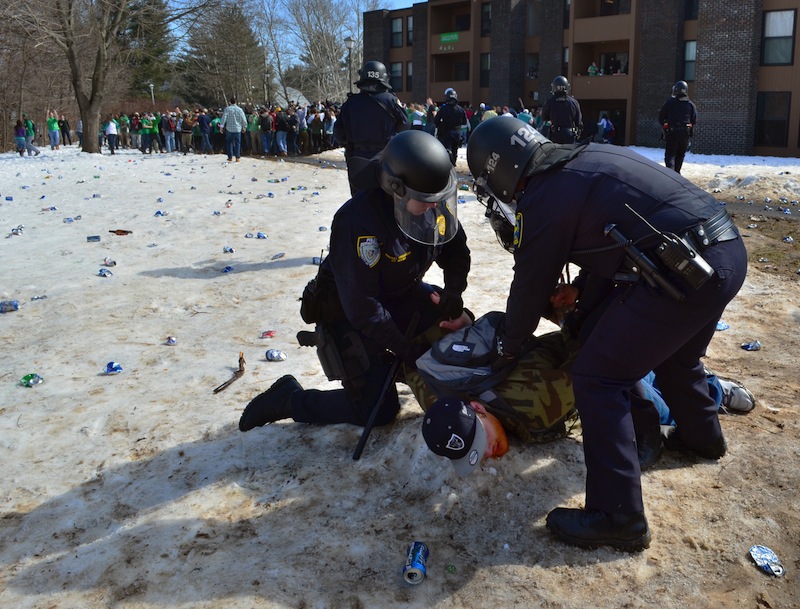 Police detain a participant in the pre-St. Patrick's Day "Blarney Blowout" near the University of Massachusetts in Amherst on Saturday.
