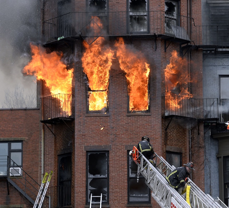 Boston firefighters work a fire on Beacon Street on Wednesday, March 26, 2014.