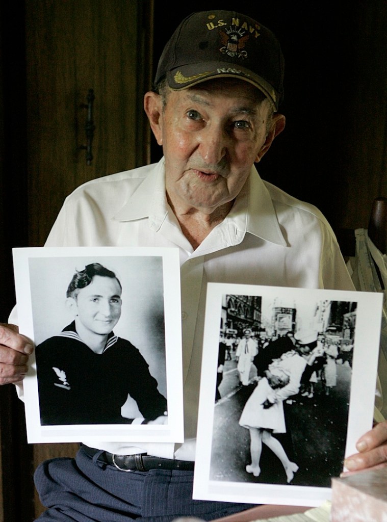 In this July 31, 2007 file photo, Glenn McDuffie holds a portrait of himself as a young man, left, and a copy of Alfred Eisenstaedt's iconic Life magazine shot of a sailor, who McDuffie claims is him, embracing a nurse in a white uniform in New York's Times Square, at his Houston home. McDuffie, who became known for claiming he was the sailor kissing a woman in Times Square in a famous World War II-era photo taken by a Life magazine photographer has died. Houston Police Department forensic artist Lois Gibson, who says she identified McDuffie as the man in the picture, says Friday, March 14, 2014 that he died March 9. McDuffie was 86.
