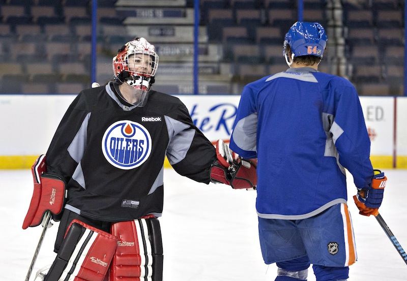 Canadian Olympic women's team goalie Shannon Szabados gives a low-five to Nail Yakupov during practice with the Edmonton Oilers NHL hockey team Wednesday.