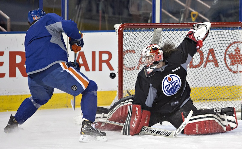 Canadian Olympic women's team goalie Shannon Szabados makes a save on Nail Yakupov as she takes part in the the Edmonton Oilers NHL hockey practice in Edmonton, Alberta, on Wednesday.