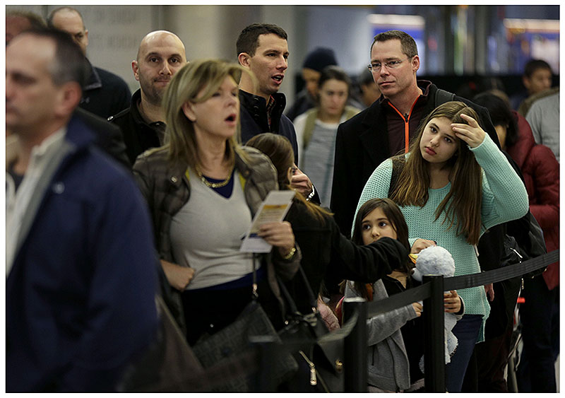 Coach passengers wait in line to board a flight at LaGuardia Airport in New York.