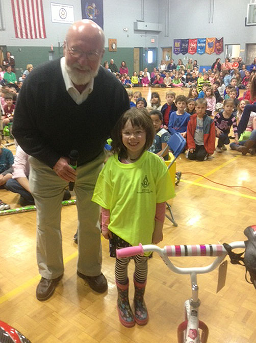 Larry Vennell of the Free Mason Arundel Lodge Post No. 76 and kindergartener Lillian Lavery of the Kennebunkport Consolidated School with one of the 22 bicycles raffled off as prizes for students who participated in a literacy initiative at the school.