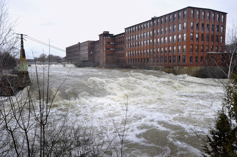 In this December 2010 file photo, high water on the Presumpscot River flows over Westbrook's Saccarappa Falls. Environmental and city officials have an agreement with Sappi Fine Paper that gives the company a two-year extension of a 2015 deadline to construct a fish passage at the Saccarappa Falls dam on the Presumpscot River.