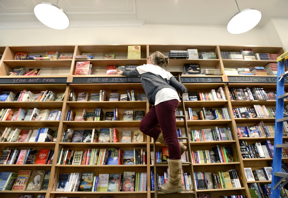 Buyer Tori Curtis stocks shelves Monday at Sherman’s Books and Stationery, which will open Tuesday on Exchange Street in Portland.