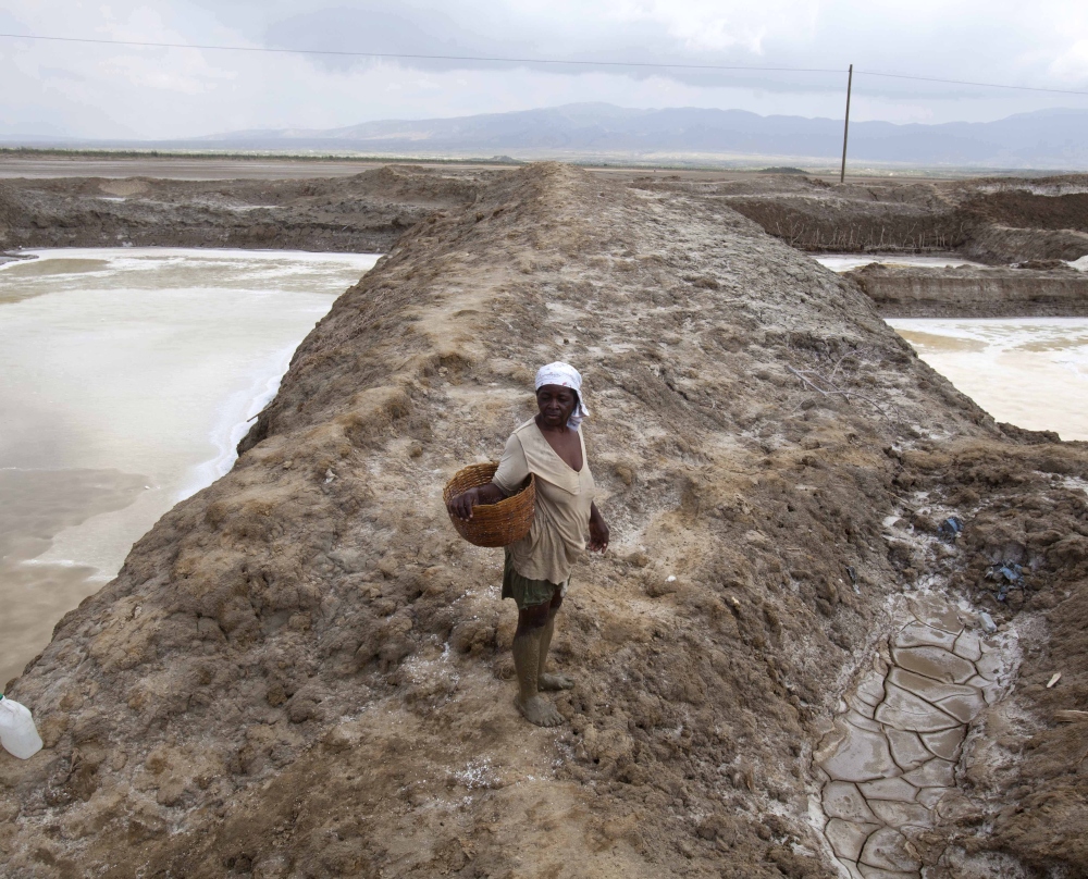 A worker suffering from heat exhaustion leaves her shift early at the salt evaporation ponds in Haiti as drought has hit the region, one of the hungriest, most desolate parts of the nation.