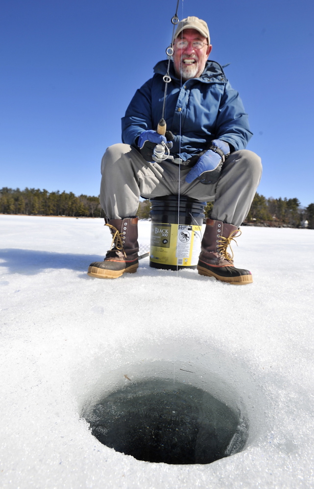Peter Brawn of Cape Elizabeth fishes in a hole cut about 18 inches deep on Sebago Lake Tuesday.