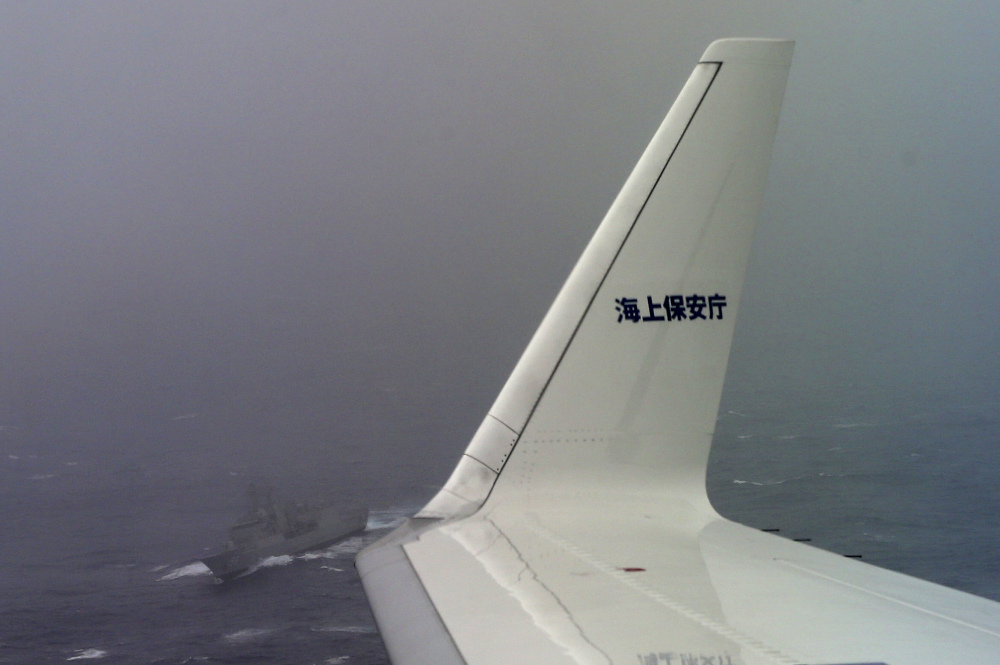 A Japan Coast Guard Gulfstream aircraft flies past HMAS Toowoomba as they both conduct searches for the missing Malaysia Airlines Flight MH370 in Southern Indian Ocean, near Australia, Tuesday, April 1, 2014. Bad weather and poor visibility caused the search to be called off early with the coast guard plane only completing one of its three 210 nautical mile legs. The letters in the winglet read: “Coast Guard.”