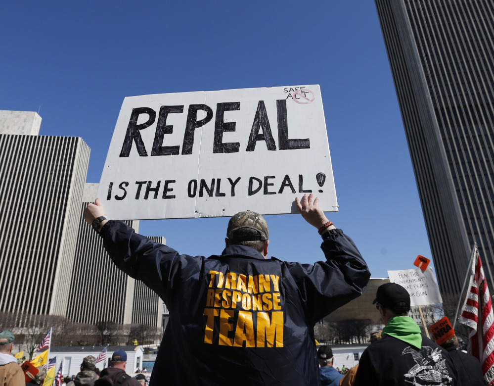 A gun rights activist holds a sign during a rally Tuesday at the Empire State Plaza in Albany, N.Y. Activists are seeking a repeal of a 2013 state law that outlawed the sales of some popular guns like the AR-15.