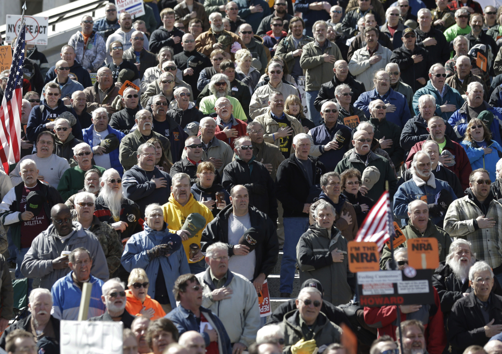 Gun rights activists recite the Pledge of Allegiance Tuesday during a rally at the Empire State Plaza in Albany, N.Y. They were protesting a restrictive 2013 gun law and new gun control proposals announced Tuesday.