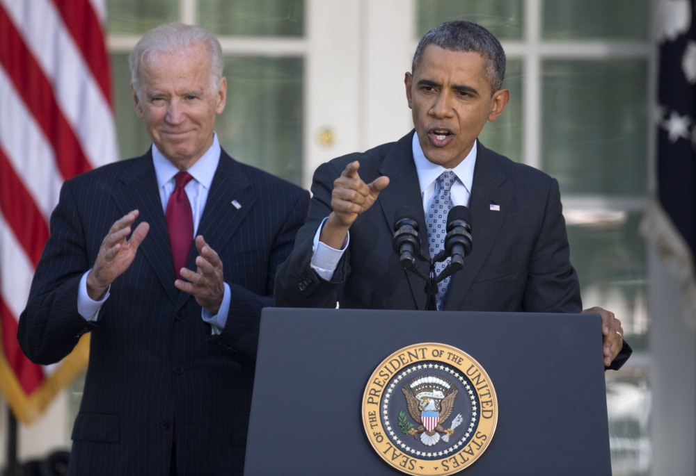 President Barack Obama, with Vice President Joe Biden, speaks in the Rose Garden of the White House in Washington on Tuesday, the day after the deadline to sign up for health insurance under the Affordable Care Act.
