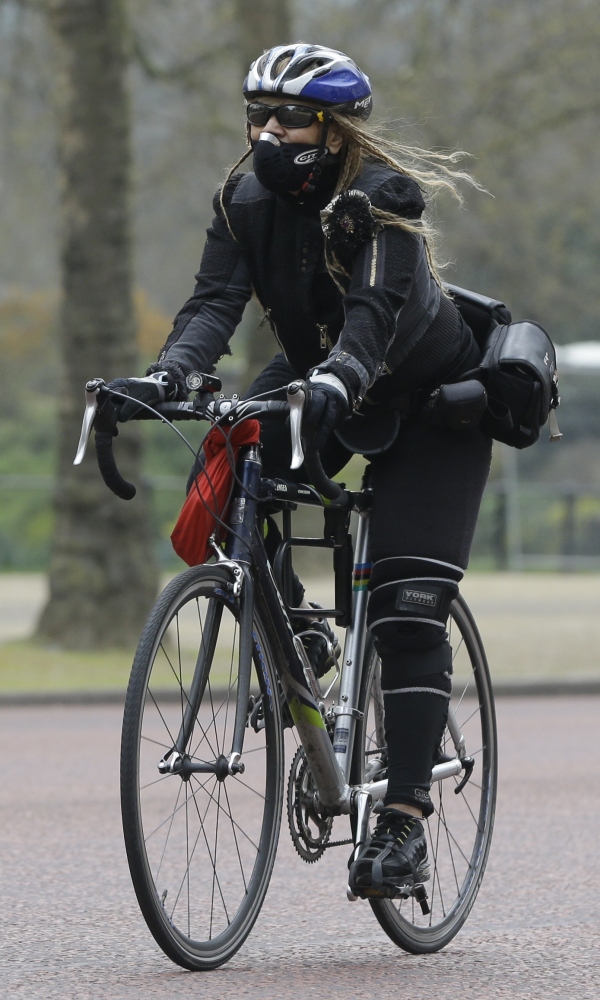 A cyclist wears a mask as she cycles along The Mall in London on Wednesday.