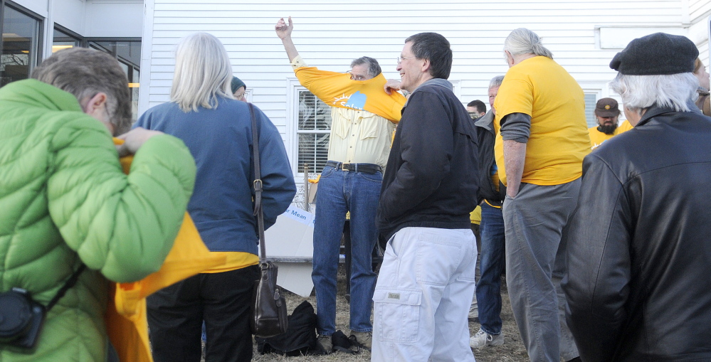 Supporters of solar energy put on yellow t-shirts Wednesday outside of the Public Utility Commissions offices in Hallowell before a hearing for Central Maine Power’s request for a rate increase. About two dozen people attended the gathering.