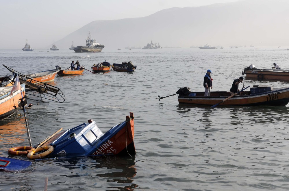 Fishing boats lie damaged in the town of Iquique, Chile, Wednesday after a magnitude-8.2 earthqauke and small tsunami struck the northen coast. Authorities lifted tsunami warnings for Chile’s long coastline early Wednesday.