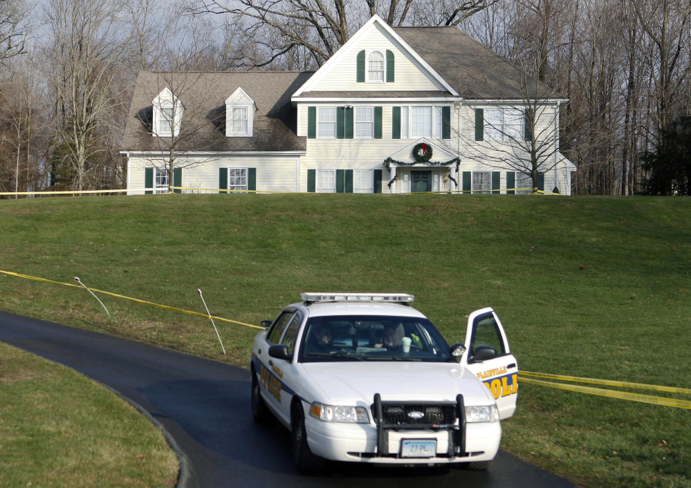 In this 2012 photo, a police cruiser sits in the driveway as crime scene tape surrounds the home of Nancy Lanza in Newtown, Conn.