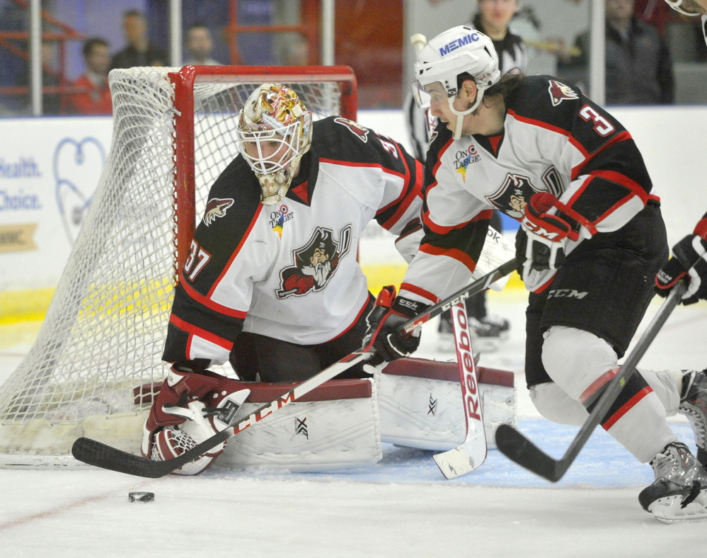 Pirate defenseman Daine Todd looks to clear a rebound after a save by goalie Louis Domingue.