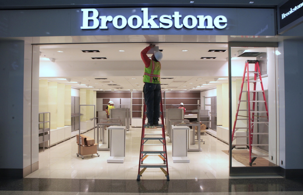 In this photo taken in September 2011, work is done on a light fixture at the Brookstone shop in a new terminal at the Sacramento International Airport in Sacramento, Calif. Brookstone, the retailer of gadgets such as virtual keyboards and personal drones, sought bankruptcy protection to pursue a sale to Spencer Spirit Holdings as consumers spend less on non-essentials.