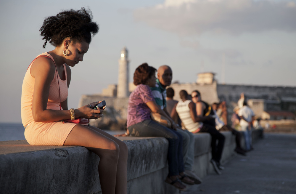 A woman uses her cellphone as she sits on the Malecon in Havana, Cuba, recently. The U.S. Agency for International Development masterminded the creation of a “Cuban Twitter,” a communications network designed to undermine the communist government in Cuba, built with secret shell companies and financed through foreign banks.
