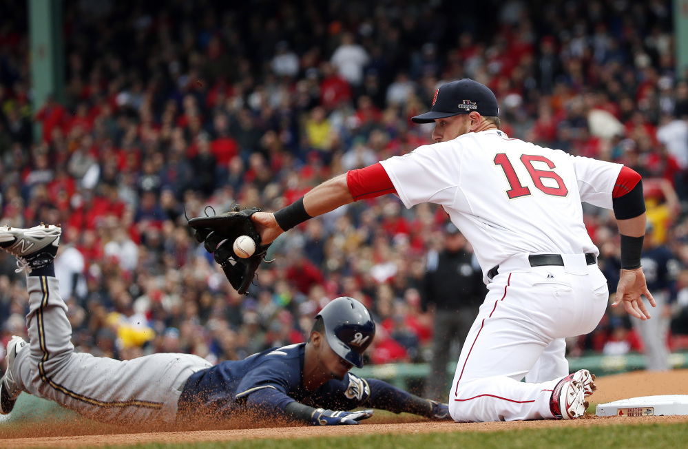Milwaukee Brewers’ Jean Segura slides in safely with a triple as Boston Red Sox third baseman Will Middlebrooks (16) takes in the throw from left field during the first inning of a baseball game at Fenway Park in Boston on Friday.
