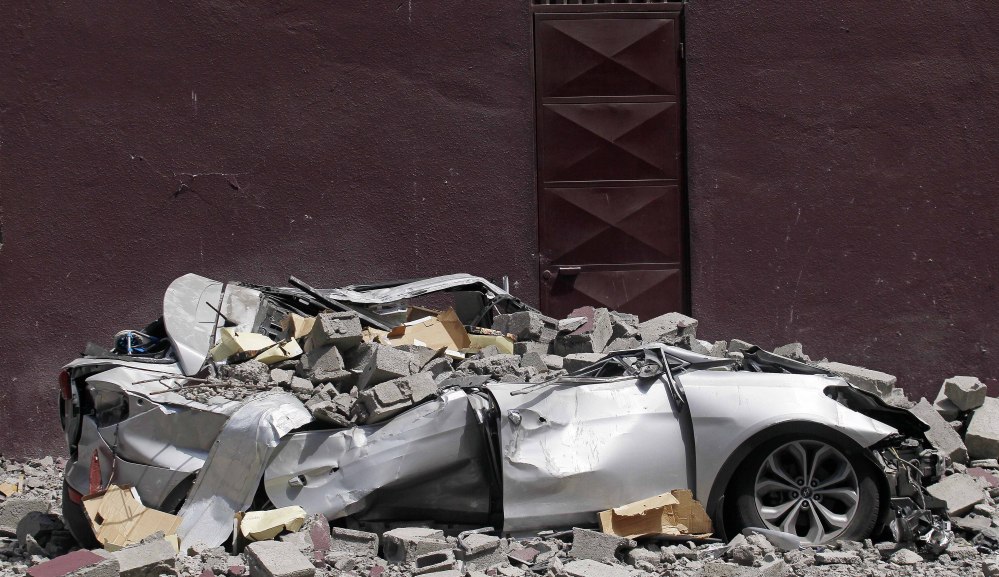 Debris from a magnitude-8.2 quake covers a car Friday in Iquique, Chile. The city remained largely peaceful.