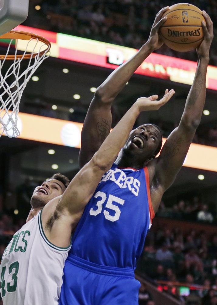 Henry Sims of the Philadelphia 76ers, right, hauls down a rebound over Kris Humphries of the Boston Celtics during the first quarter of the 76ers’ 111-102 victory Friday night at Boston.