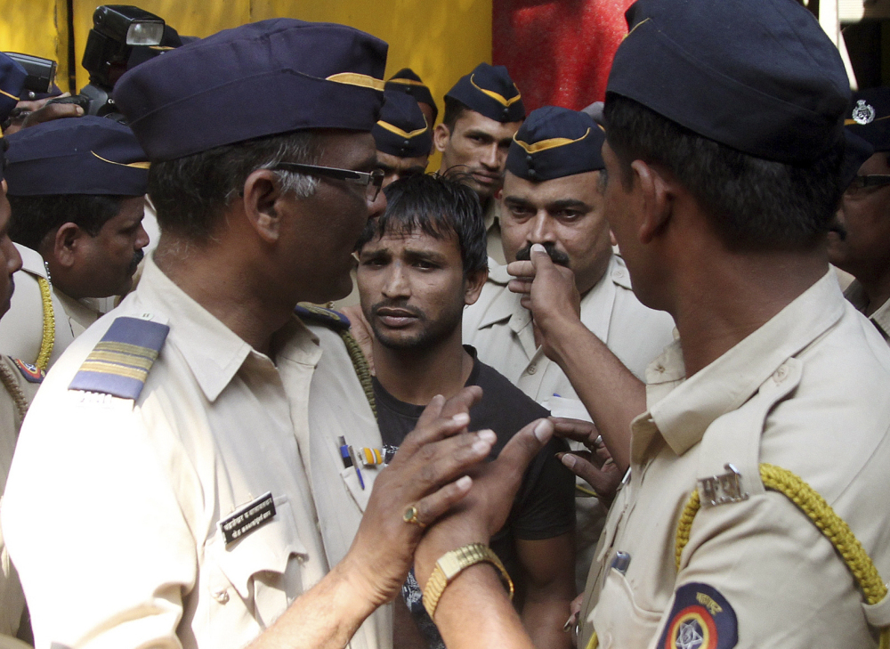 Police escort one of the four convicts in a gang rape to a court in Mumbai, India, on Friday. The court sentenced three of the men to death. A fourth got life in prison.