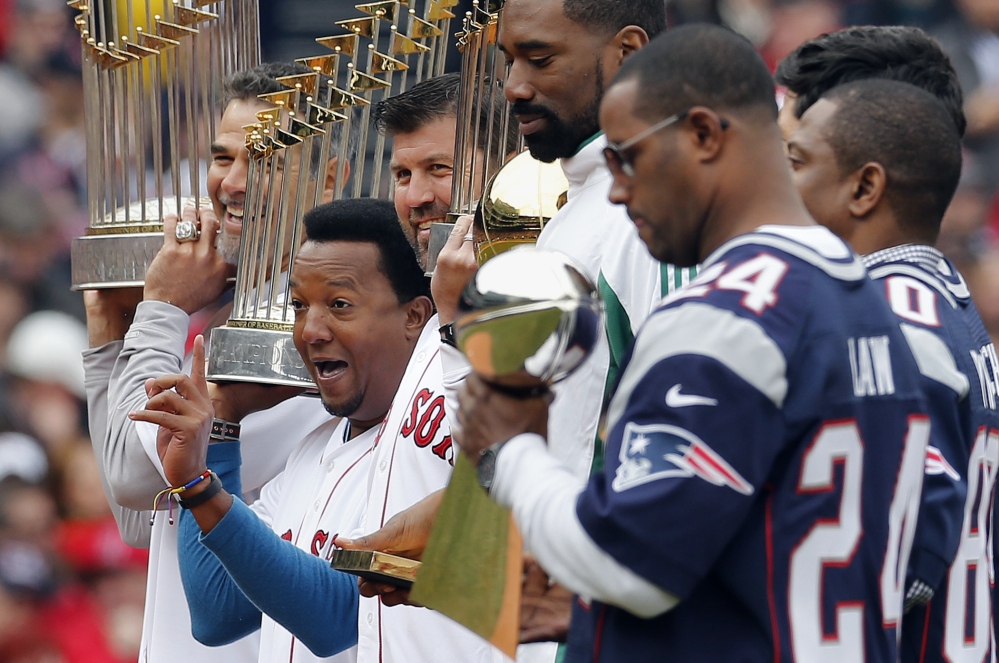 Former Boston Red Sox player Pedro Martinez, second from left, stands with Mike Lowell, left, Jason Varitek, former Boston Celtics’ Leon Powe, fourth from left, and former players from the New England Patriots during pre-game ceremonies before a baseball game against the Milwaukee Brewers on bpening day at Fenway Park in Boston on Friday.