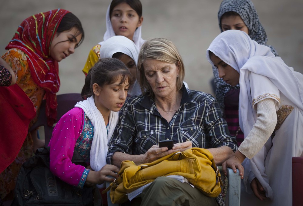 Regional Correspondent Kathy Gannon sits with girls at a school in Kandahar, Afghanistan, in this 2011 photo. Gannon, who was wounded Friday, is a Canadian journalist based in Islamabad for AP.