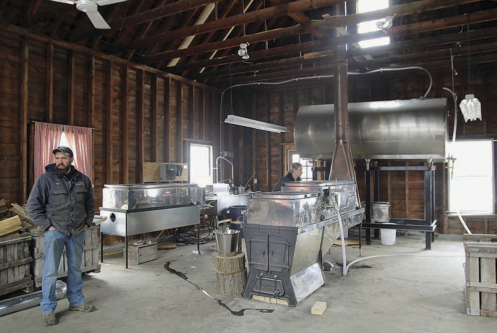 Jim Lattanzi, co-owner of the Hollis Hills Farm in Fitchburg, Mass., talks about the farm’s maple syrup production, as his wife, Allison, checks new equipment in their sugar house. The farmers are expanding after buying another farm in Fitchburg.