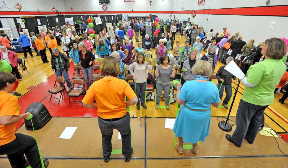 Women watch and participate in an elastic band exercise demonstration Saturday at the 17th annual World of Women’s Wellness, sponsored by Inland Hospital at Thomas College.