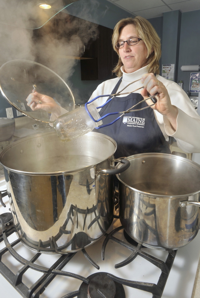 Kathy Savoie, extension educator, makes flavored vinegar at the University of Maine Cooperative Extension test kitchen in Falmouth.