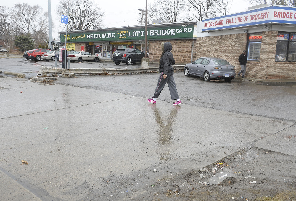 A pedestrian passes by the scene of an attack on Wednesday in Detroit.