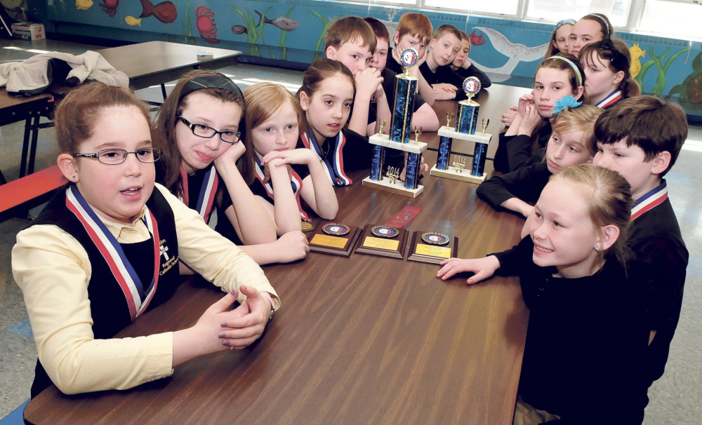 TEAM WORK: Student Dorothy Anne Giroux-Pare, left, and members of the St. John Catholic School Odyssey of the Mind team discuss going to the World Championship competition in Iowa this May at the Winslow school.