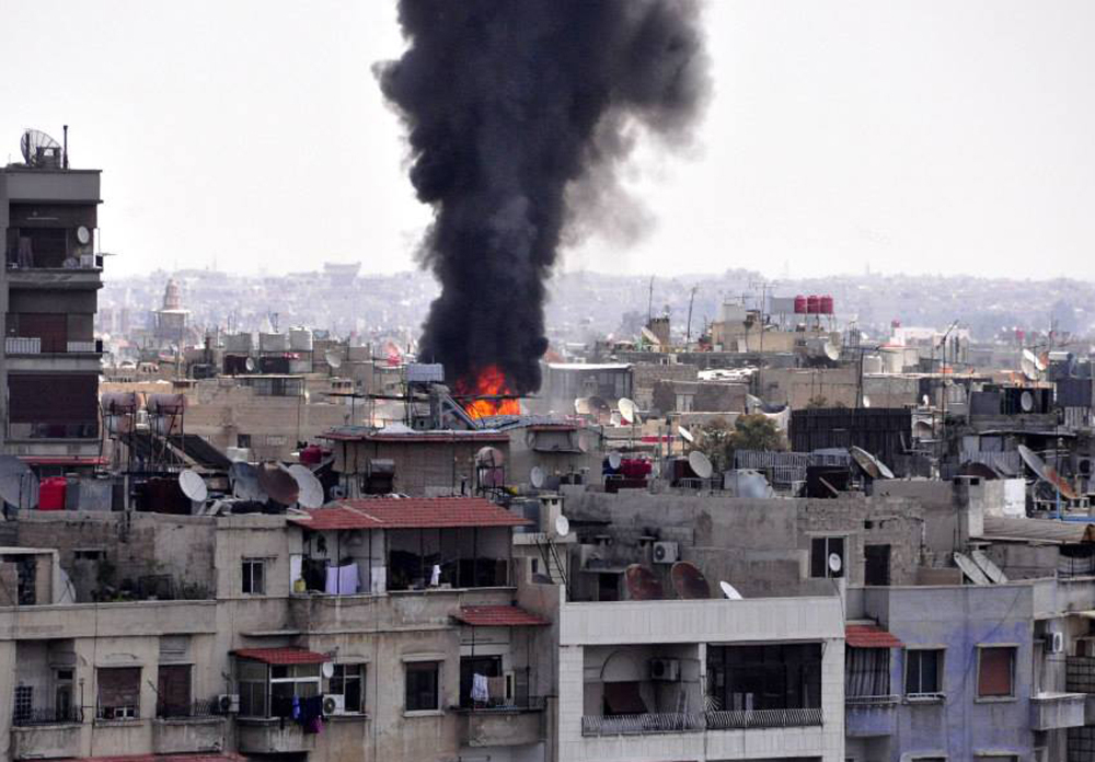 Smoke and flames rise from a building that was attacked by a mortar shells in Damascus, Syria, on Saturday.
