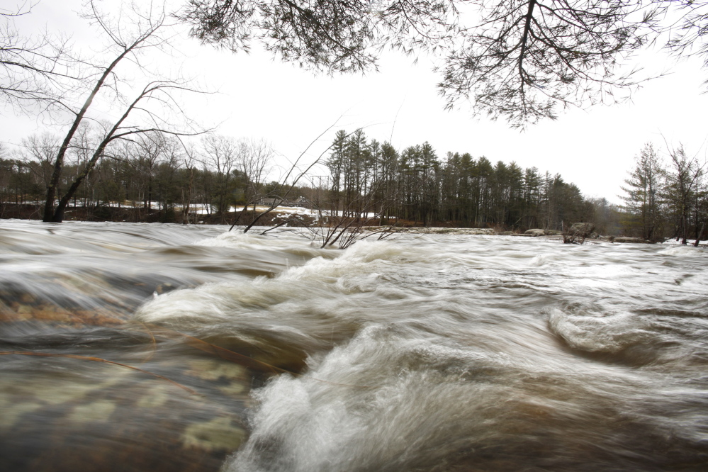 On the Saco River in Standish on Tuesday, water flows over rocks that are normally above water. Flooding from heavy rains on Monday was minimal.