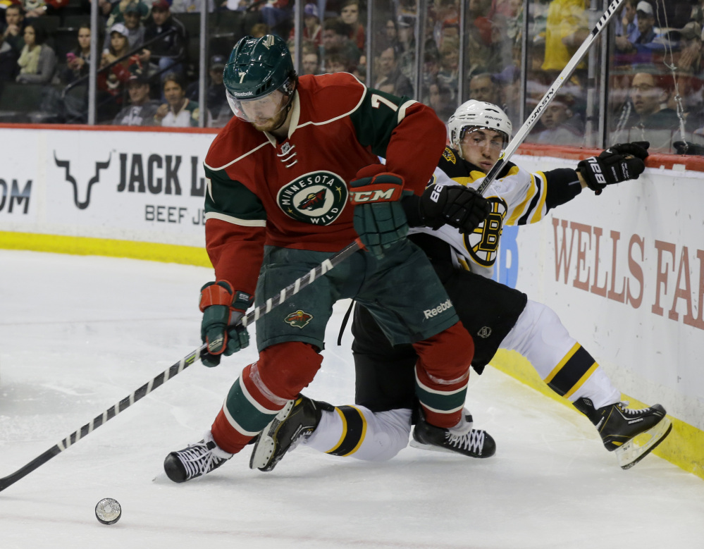 Wild defenseman Jonathon Blum fights off Boston’s Brad Marchand for the puck in the second period Tuesday night in St. Paul, Minn. The Wild rallied to win 4-3 in a shootout to clinch a playoff berth.