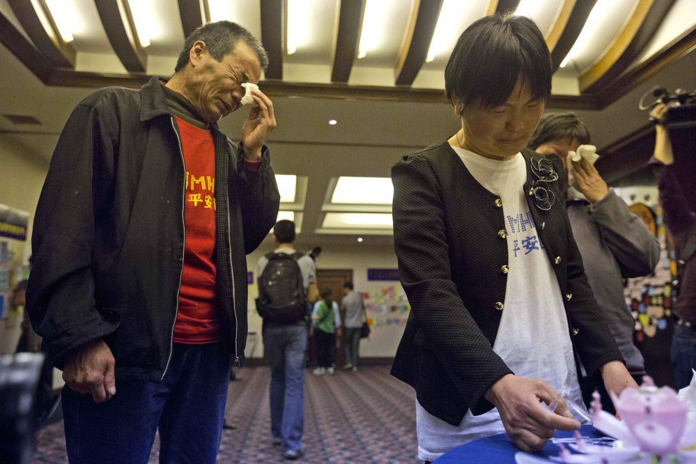 Feng Zhishang, left, cries near Xie Xincui as they mark the birthday of their son Feng Dong, a passenger on board the Malaysia Airlines Flight 370, at a hotel where relatives gather to wait for news of the missing plane in Beijing, China, on Tuesday.