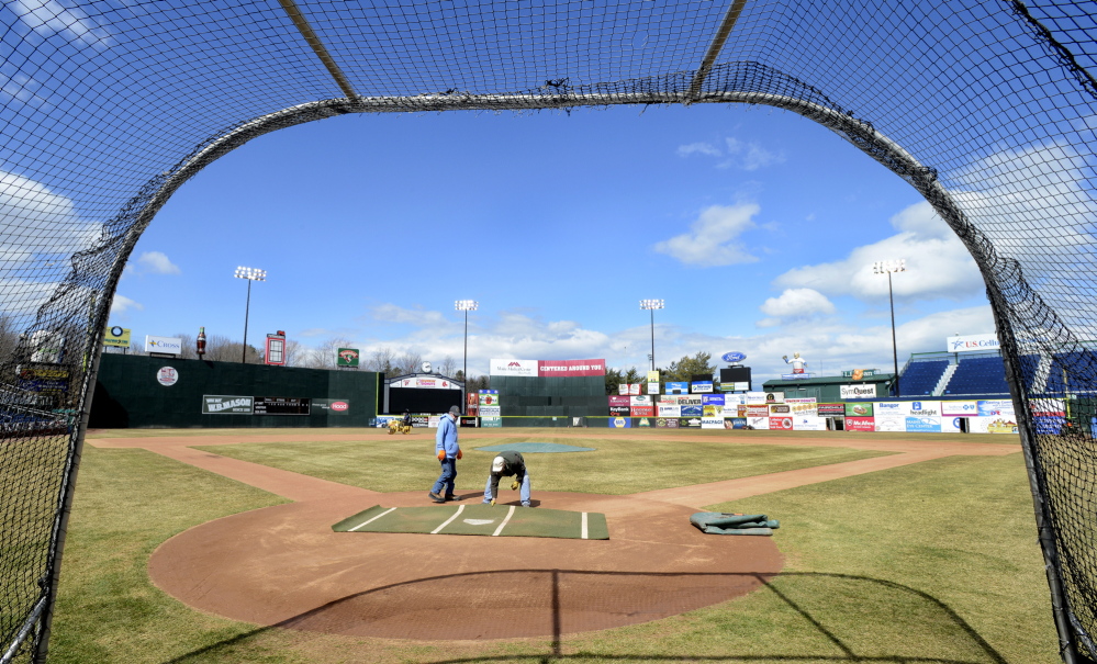Framed by the batting cage, Steve Smith and Mike Diffin, members of the Portland Sea Dogs’ grounds crew and staff, prepare Hadlock Field on Wednesday for tonight’s home opener. The minor league team this season has plenty of top prospects, including pitcher Henry Owens, whose first start in Portland is set for Monday.