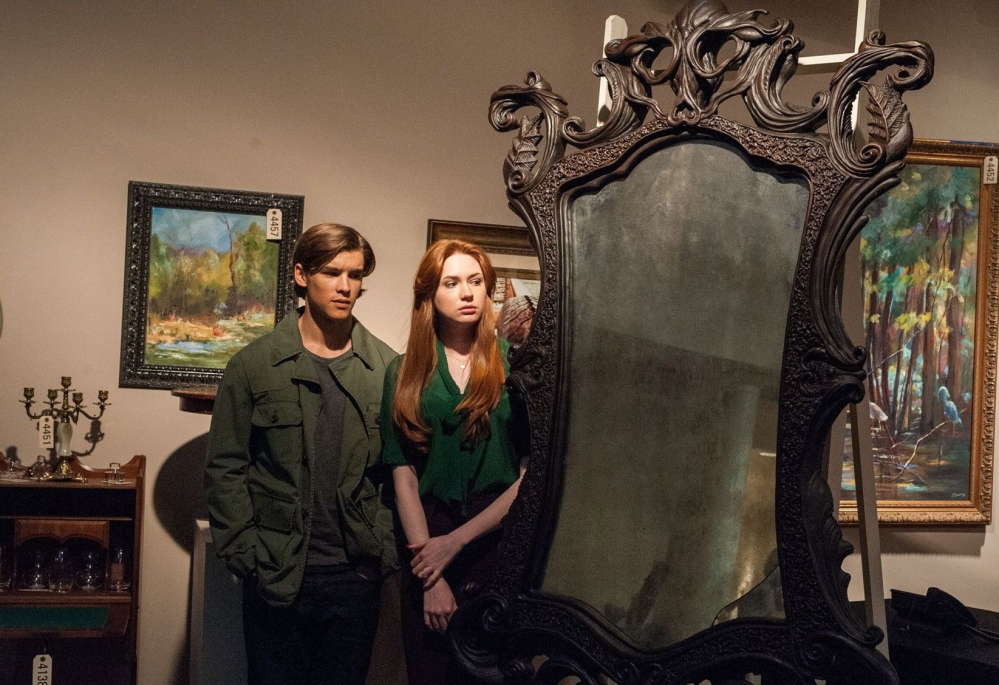 Brenton Thwaites as Tim Russell and Karen Gillan as Kaylie Russell with the mysterious mirror in “Oculus.”