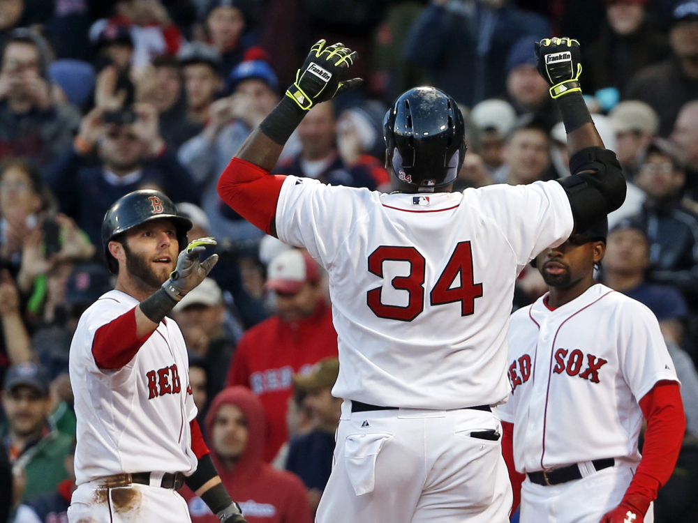 Boston Red Sox’s David Ortiz (34) celebrates at the plate after hitting a three-run homer, scoring Dustin Pedroia, left, and Jackie Bradley Jr., right, in the eighth inning of a baseball game against the Texas Rangers at Fenway Park in Boston, Wednesday, April 9, 2014. The Red Sox won 4-2.
