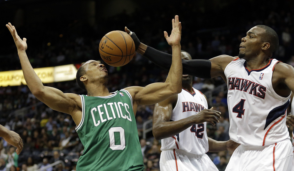 Paul Millsap of the Atlanta Hawks, right, reaches for a loose ball against Avery Bradley of the Boston Celtics in the fourth quarter of Atlanta’s 105-97 victory Wednesday night.