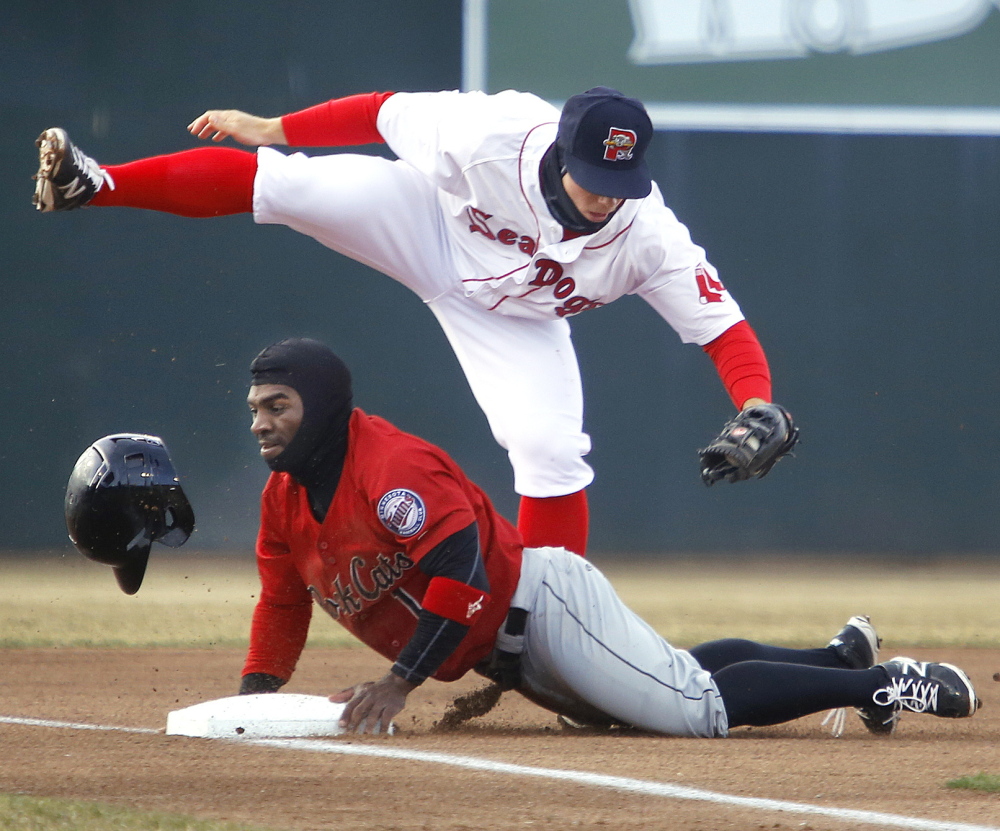 Sean Coyle of the Portland Sea Dogs tags out Corey Wimberly of the New Britain Rock Cats, who was attempting to go from second to third on a grounder to short in the first inning Thursday night. Portland won its home opener, 6-4.