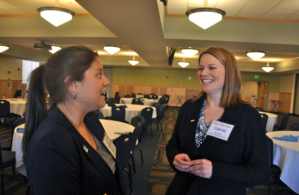 Kelsey Bolduc, left, a chemical engineering student at the University of Maine, tells Carrie Enos, president of the Maine Pulp and Paper Foundation, about her decision to pursue a career in the paper industry rather than the legal field.