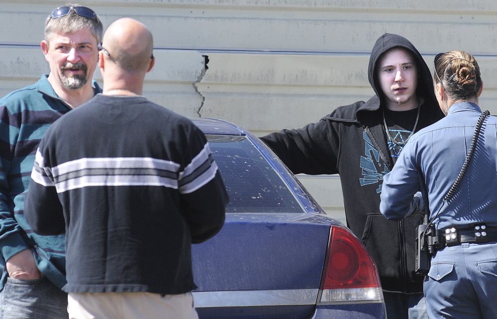 Frederick Horne Sr., left, and Frederick Horne Jr. speak with Maine State Police officers Thursday after being cited on charges of sex trafficking at their Sidney residence.