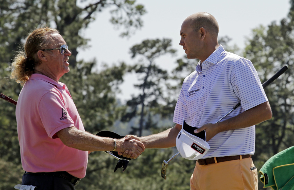Miguel Angel Jimenez, of Spain, shakes hands with Bill Haas, right, on the 18th green following their first round of the Masters golf tournament Thursday in Augusta, Ga.