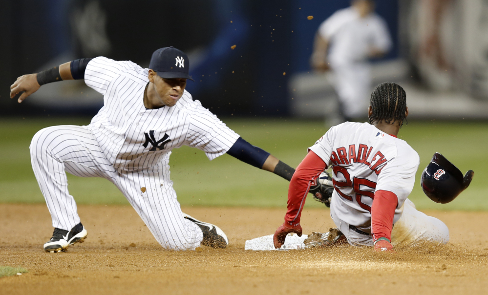 Boston Red Sox’s Jackie Bradley Jr. is safe sliding into second base on a third-inning stolen base as Yankees third baseman Yangervis Solarte applies the tag but loses the ball.