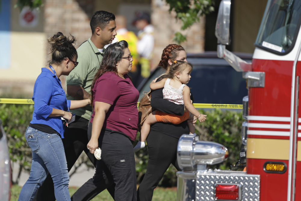 Parents and relatives leave a day care center in Winter Park, Fla., with their children Wednesday after a vehicle crashed into the center, killing a girl and injuring 14 others, at least a dozen of them children, authorities said.